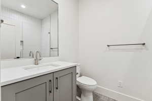 Full bath featuring vanity, recessed lighting, and tiled shower