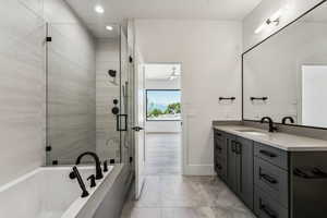 Full bath featuring vanity, a shower stall, a bath, and recessed lighting