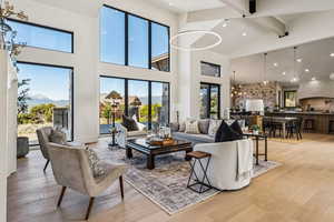 Living area featuring beamed ceiling, recessed lighting, a chandelier, light wood-style floors, and high vaulted ceiling