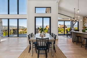 Dining space featuring a mountain view, a chandelier, light wood finished floors, and a high ceiling