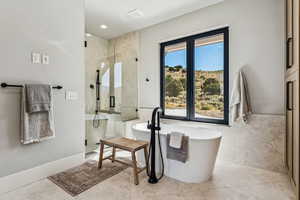 Full bath with a shower stall, a freestanding bath, light tile patterned floors, tile walls, and recessed lighting