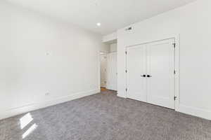 Unfurnished bedroom featuring carpet floors, a closet, and recessed lighting
