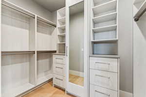 Spacious closet featuring light wood-type flooring