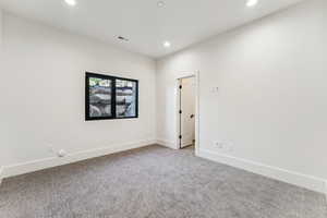 Carpeted spare room featuring baseboards and recessed lighting