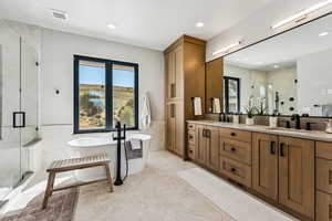 Bathroom with tile walls, a marble finish shower, wainscoting, double vanity, and a freestanding bath