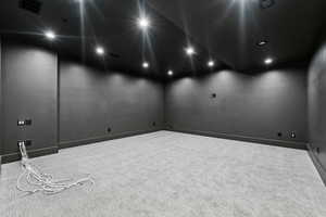 Carpeted empty room with elevator and recessed lighting