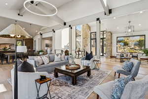 Living area with beam ceiling, recessed lighting, a chandelier, a barn door, and light wood-type flooring