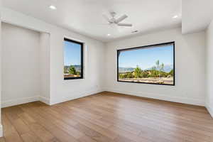 Spare room with light wood finished floors, recessed lighting, a ceiling fan, and a mountain view