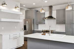 Kitchen with gray cabinetry, stainless steel fridge, and dark wood finished floors