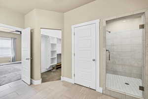 Bathroom with a stall shower and a spacious closet