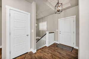 Foyer entrance with dark wood finished floors and suspended lighting