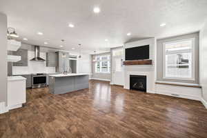 Kitchen featuring gray cabinetry, open floor plan, light countertops, stainless steel electric range oven, and a textured ceiling