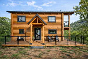 Back of property featuring a wooden deck and log siding
