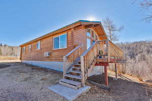 Rear view of property with stairway and a metal roof