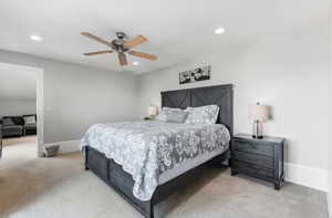 Bedroom with light carpet, ceiling fan, and recessed lighting