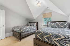 Bedroom featuring light colored carpet and lofted ceiling