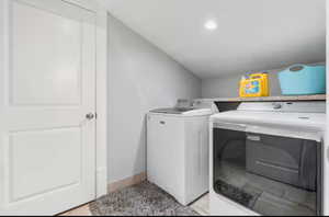 Laundry area featuring washer and dryer and lofted ceiling