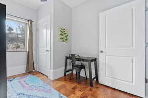 Office with light wood-type flooring and baseboards