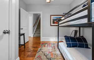 Bedroom with dark wood-style flooring and baseboards