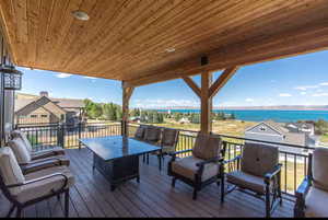 Wooden deck with an outdoor lounge area and a water view