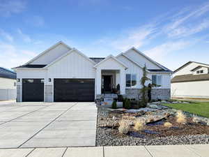 View of front of house featuring board and batten siding, a garage, and concrete driveway