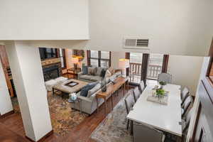 Living area featuring dark wood-style flooring, a fireplace, and a high ceiling