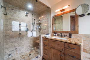 Bathroom featuring vanity and a shower stall