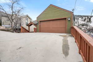 Snow covered garage with a detached garage