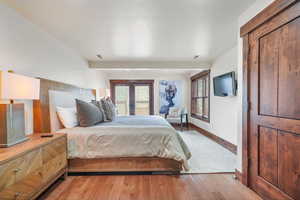 Bedroom featuring light wood-type flooring, multiple windows, and french doors