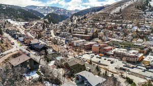 Aerial overview of property's location featuring a mountainous background and nearby suburban area
