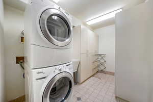 Laundry area with stacked washer / drying machine and cabinet space