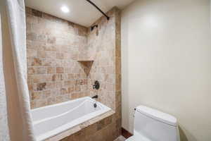 Full bathroom with tiled shower / bath combo and recessed lighting