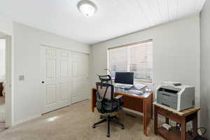 Office space featuring light colored carpet and wood ceiling