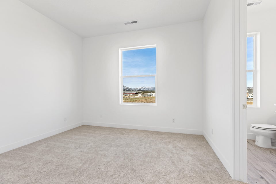 Empty room featuring light carpet and baseboards