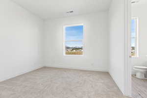 Empty room featuring light carpet and baseboards
