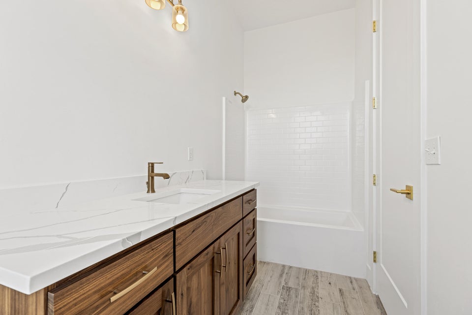 Full bathroom with vanity, light wood-type flooring, and bathtub / shower combination