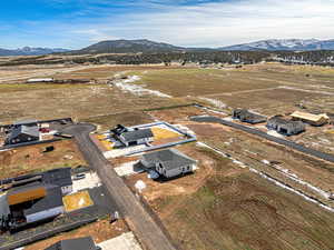 Aerial view of property and surrounding area with nearby suburban area and a mountain backdrop