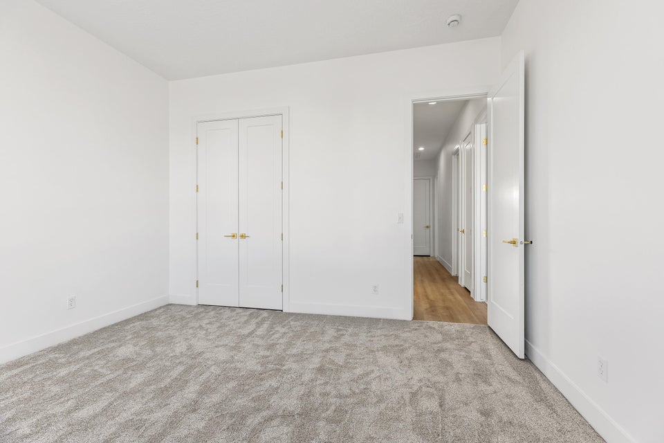 Unfurnished bedroom with light carpet and a closet