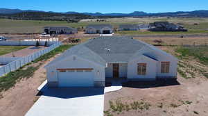 View of front facade featuring a mountain view, a garage, and stucco siding