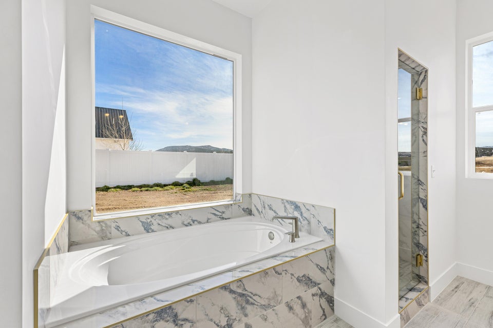 Full bath with a bath and a marble finish shower