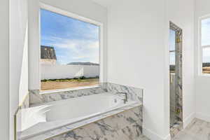 Full bath with a bath and a marble finish shower