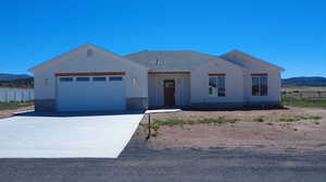 View of front of house featuring a mountain view, a garage, and driveway