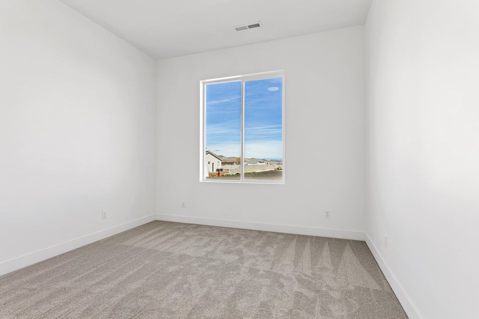 Spare room with light colored carpet and baseboards