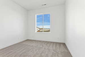 Spare room with light colored carpet and baseboards
