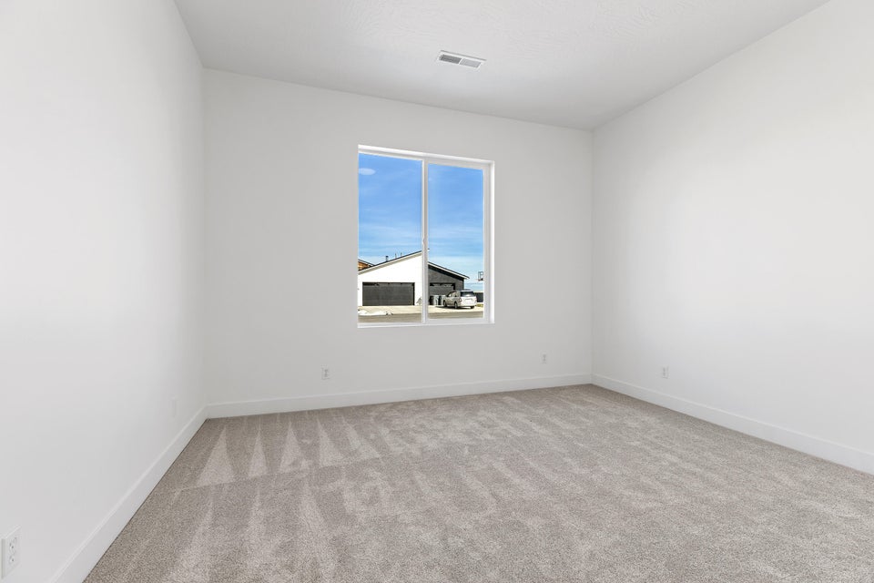 Spare room with light colored carpet and baseboards