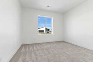 Spare room with light colored carpet and baseboards
