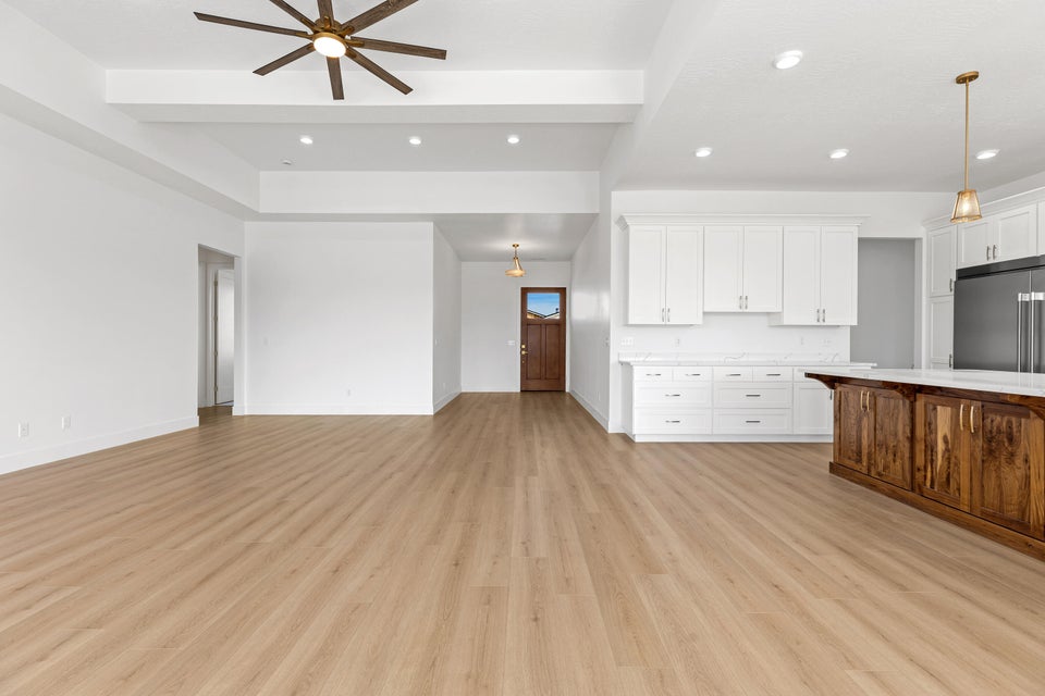 Unfurnished living room featuring recessed lighting, light wood-type flooring, ceiling fan, and beamed ceiling