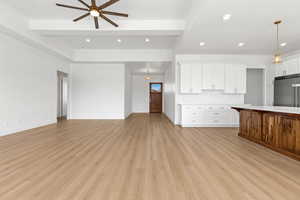 Unfurnished living room featuring recessed lighting, light wood-type flooring, ceiling fan, and beamed ceiling