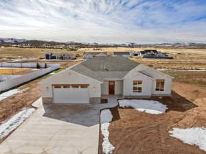 View of front of house with a garage, driveway, a mountain view, stucco siding, and a shingled roof