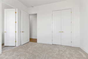 Unfurnished bedroom featuring light colored carpet and a closet
